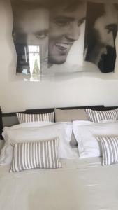 una camera con un letto bianco con due immagini sul muro di Casa di Anna a Ostuni