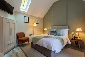 a bedroom with a large bed and a chair at The Ostrich Inn in South Creake