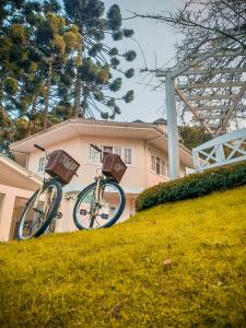 two bikes parked on a hill in front of a house at Pousada Nacional Inn Campos do Jordão in Campos do Jordão