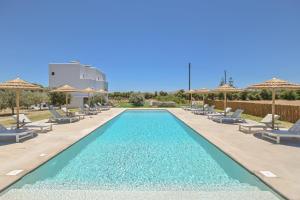 a swimming pool with chairs and umbrellas at a resort at Ktima Lino in Agia Anna Naxos
