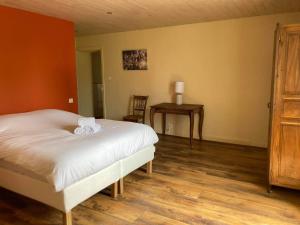 a bedroom with a white bed and a table at Maison de charme en Périgord 10 personnes La maison d'Albertine in Peyrillac-et-Millac