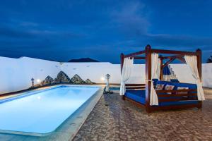 a resort pool with a bed and a bed and a tent at Casa Delfín Playa Blanca in Playa Blanca