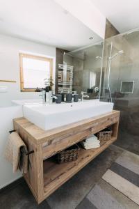 bagno con grande lavandino bianco e specchio di Voglstätter Appartements Lofer a Lofer