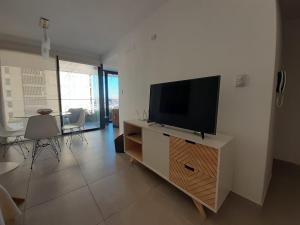 a living room with a flat screen tv on a cabinet at Departamento a estrenar in San Miguel de Tucumán