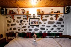 pared de piedra con mesa en una habitación en Къща за гости Даутев Връх, en Bansko