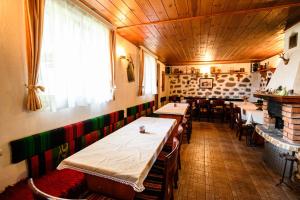 una habitación con mesas y sillas en un restaurante en Къща за гости Даутев Връх en Bansko