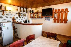 uma cozinha com um bar com uma mesa e um frigorífico em Къща за гости Даутев Връх em Bansko