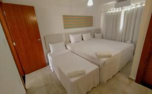 a white bedroom with a bed and a couch at Arraial D'Ajuda, Altos da pitinga ,3 suítes in Arraial d'Ajuda +32 photos