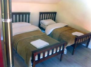 2 letti posti uno accanto all'altro in una stanza di Soha Village Resort a Fālūghā