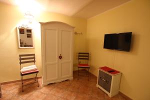 Zimmer mit 2 Stühlen und einem Flachbild-TV in der Unterkunft Bed And Breakfast Majore in Nuoro