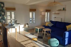 a living room with a blue couch and a desk at Superbe appartement rénové 4 personnes Le Zen Scandi au centre ville - Draps - Serviettes Parking - in La Roche-Chalais