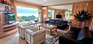 een woonkamer met een bank en een tafel bij Villa Le France - Vision Luxe in Veyrier-du-Lac