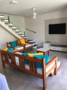 a room with a bunch of chairs and a tv at Arraial D'Ajuda, Altos da pitinga ,3 suítes in Arraial d'Ajuda