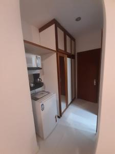 uma pequena cozinha com frigorífico e micro-ondas em Suite Real Residencial no Rio de Janeiro