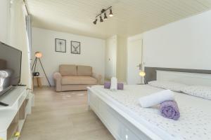 een witte slaapkamer met een groot bed en een bank bij Apartment Petric in Hvar