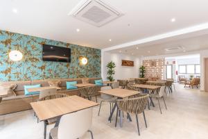 a restaurant with tables and chairs and a tv on the wall at Hostal Rosell Boutique in San Antonio