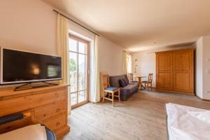 a living room with a large flat screen tv at Hotel Garni Zum Hirschen in Malles Venosta