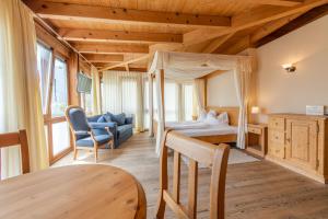 een slaapkamer met een bed en een tafel in een kamer bij Hotel Garni Zum Hirschen in Malles Venosta