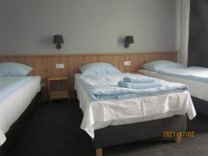 a hotel room with two beds with towels on them at Fregata in Wilkasy