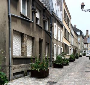Une allée avec des plantes en pot sur le côté d'un bâtiment dans l'établissement Studio 2 pers en vieille ville parking gratuit - by La Source d'OrFée, à Boulogne-sur-Mer