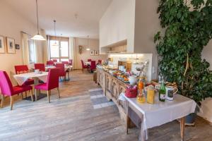 a restaurant with tables and chairs and a counter with food at Hotel Garni Zum Hirschen in Malles Venosta