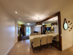 een eetkamer en woonkamer met een tafel en stoelen bij Temporada Gramado e Canela - Apartamento Centro Campos de Canella in Canela