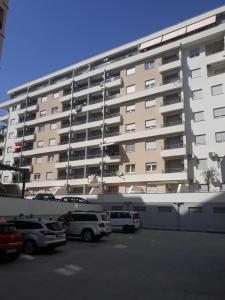 a large apartment building with cars parked in a parking lot at Apartment Boki in Budva