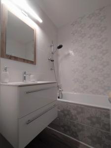 La salle de bains blanche est pourvue d'un lavabo et d'une baignoire. dans l'établissement Hanna Apartman, à Veszprém
