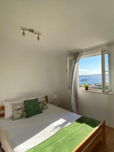 Un dormitorio con una cama con una ventana grande. en Apartmani Anka Hvar, en Hvar