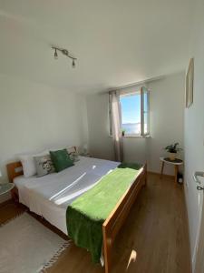 a bedroom with a large white bed with a window at Apartmani Anka Hvar in Hvar