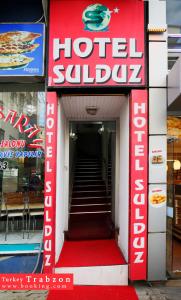 a hotel lobby with a red and white sign and stairs at Sulduz Hotel in Trabzon