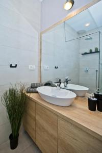 Un baño con un lavabo blanco y un espejo. en Villa Don Dan, en Žrnovnica