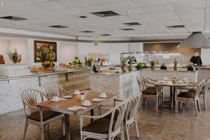 a restaurant with wooden tables and chairs and a kitchen at Hotel Los Aluxes in Mérida