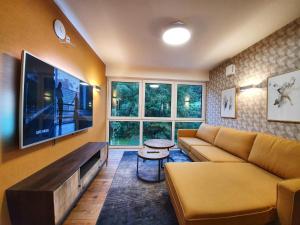a living room with a couch and a flat screen tv at Erasmus Lodge - Ferienwohnungen zum Wohlfühlen in Trassem