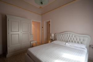 a white bed sitting in a bedroom next to a white wall at Suite Barocca in Noto
