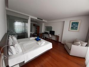 a bedroom with a large white bed and a couch at Buca Beachclub Resort in Messini