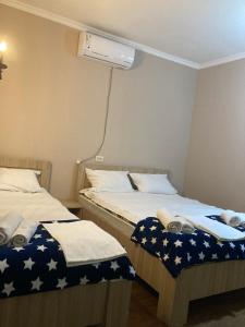 2 łóżka pojedyncze w pokoju z wentylatorem w obiekcie Happy Holiday w Achalciche