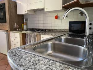 una cucina con lavello in acciaio inossidabile di Casavacanze Peperosa a Civitavecchia