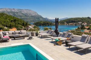 un patio con piscina y vistas al agua en Villa Buddha Bay, en Korčula