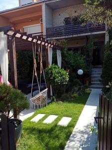 a backyard with a swing and a house at DUŠICA APARTMANI in Jagodina