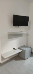 a flat screen tv hanging on a white wall at Alba de Mar B&B in Roseto Capo Spulico