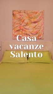 Un dormitorio con una cama amarilla con una pintura en la pared en Casa vacanze Salento en Diso