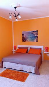 1 dormitorio con 1 cama grande y paredes de color naranja en Casa vacanze Salento en Diso