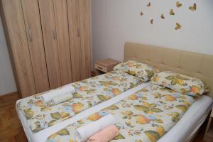 a bed with a comforter and towels on it at Apartman Luna lukavica in Lukavica