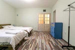 a bedroom with two beds and a blue dresser at Seosko Domaćinstvo Pustolov in Stari Banovci