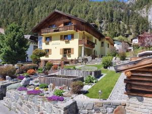 ein Haus mit Garten davor in der Unterkunft Landhaus Sonneck in Pettneu am Arlberg