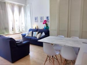 ein Wohnzimmer mit einem blauen Sofa, einem Tisch und Stühlen in der Unterkunft "Beach Cottage" monolocale vicino alla spiaggia in Chioggia