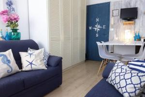 ein Wohnzimmer mit einer blauen Couch und einem Tisch in der Unterkunft "Beach Cottage" monolocale vicino alla spiaggia in Chioggia + 33 Fotos
