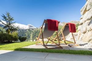 deux chaises avec des serviettes rouges dessus assises dans l'herbe dans l'établissement Landhaus Mader Hintertux, à Tux