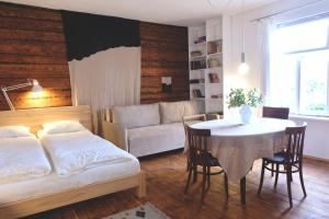 salon z łóżkiem, stołem i kanapą w obiekcie Design apartments Jūrmāja w mieście Ainaži